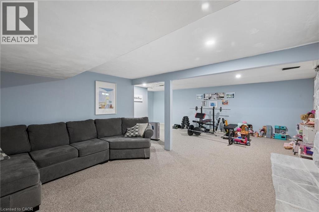 Spacious lower-level area featuring light-toned carpeting and soft blue walls - 50 Lewis Crescent, Kitchener, ON - Indoor Photo Showing Living Room