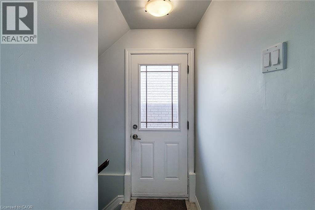 White entry door featuring a multi-pane window insert, a polished door handle, and matching white trim - 197 Cloverleaf Drive, Ancaster, ON - Indoor Photo Showing Other Room