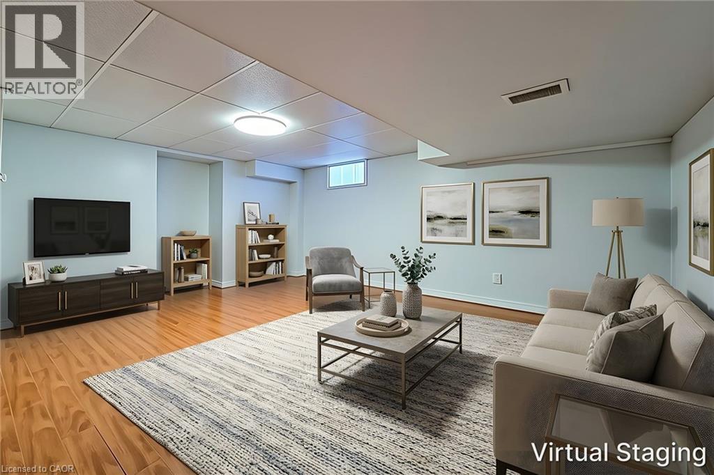 Spacious finished room featuring wood-finish flooring, light blue walls, and a recessed ceiling with integrated lighting - 197 Cloverleaf Drive, Ancaster, ON - Indoor