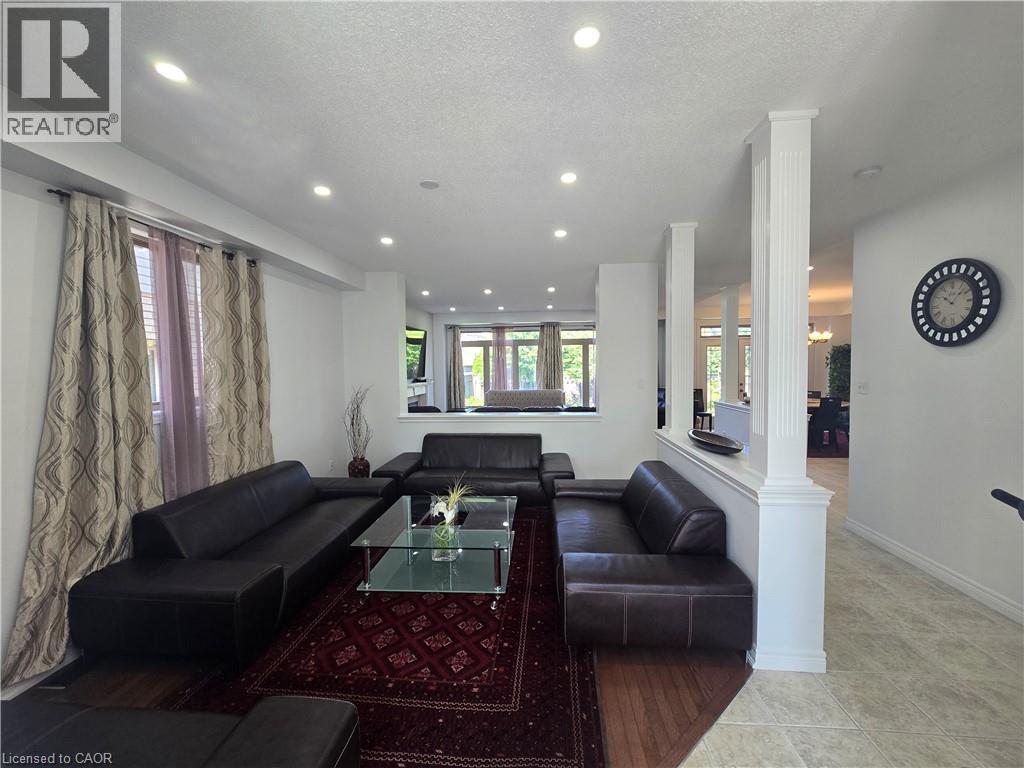 Spacious living area featuring recessed lighting, a combination of wood-finish and tiled flooring, and decorative half-walls with fluted columns - 197 Cloverleaf Drive, Ancaster, ON - Indoor Photo Showing Living Room