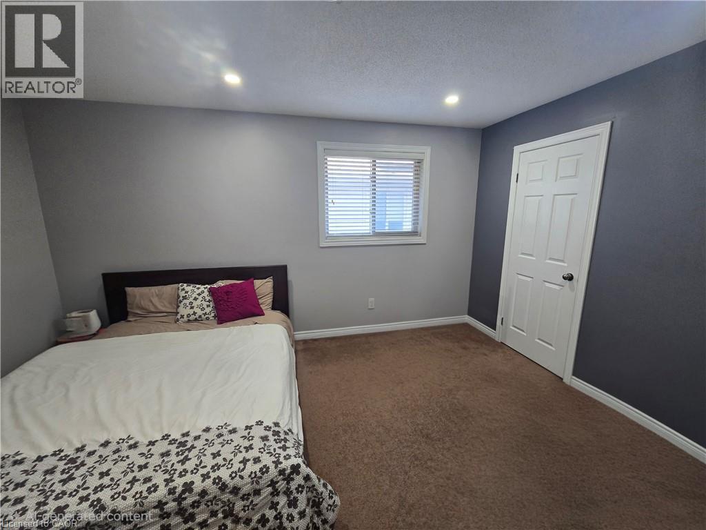Room featuring recessed lighting, a window with blinds, a paneled door, brown carpeting, and contrasting wall colors - 197 Cloverleaf Drive, Ancaster, ON - Indoor Photo Showing Other Room