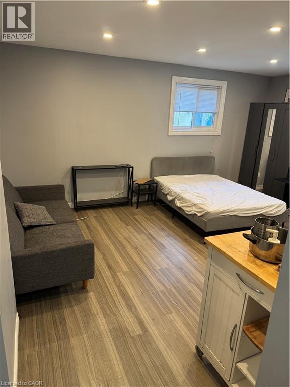 Open-concept living space with wood-finish flooring, recessed lighting, and a window with blinds - 61 E Waterloo Drive Unit# 61, Kitchener, ON - Indoor