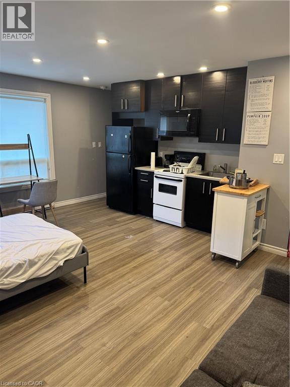 Compact living space featuring wood-finish flooring and recessed ceiling lighting - 61 E Waterloo Drive Unit# 61, Kitchener, ON - Indoor Photo Showing Kitchen