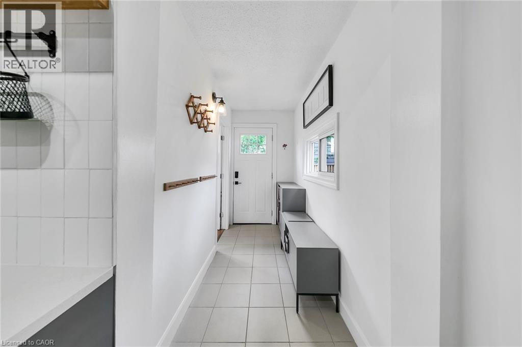 Bright entry hallway featuring light-toned square tile flooring - 501 Ferguson Avenue N, Hamilton, ON - Indoor Photo Showing Other Room
