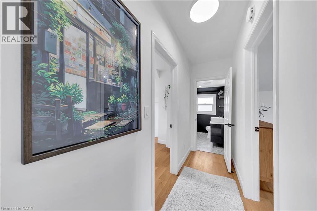 Bright hallway featuring wood-finish flooring, white walls, and a flush-mount ceiling light - 501 Ferguson Avenue N, Hamilton, ON - Indoor Photo Showing Other Room