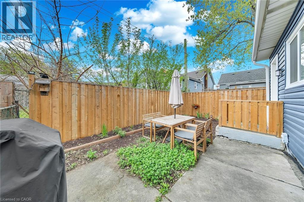 Private backyard featuring a concrete patio, wood privacy fencing, and a garden bed - 501 Ferguson Avenue N, Hamilton, ON - Outdoor