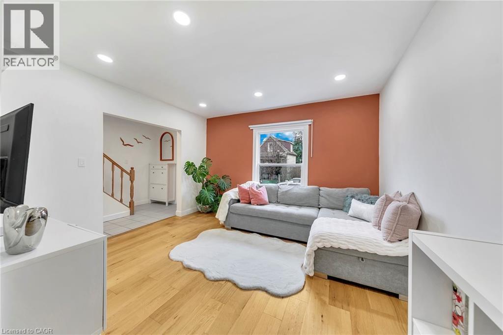 Living area featuring wood-finish flooring, recessed lighting, and a window with white trim - 501 Ferguson Avenue N, Hamilton, ON - Indoor Photo Showing Living Room