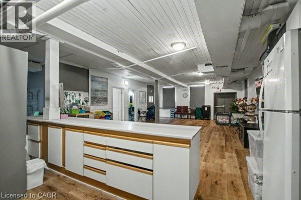 Open-concept space featuring wood-finish flooring, white paneled ceilings, and exposed ductwork - 37 Wellington Street, Cambridge, ON