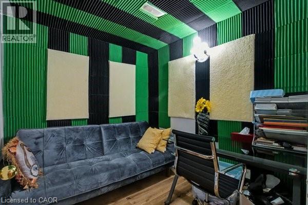Dedicated room featuring acoustic paneling on walls and ceiling, wood-finish flooring, and a wall-mounted light fixture - 37 Wellington Street, Cambridge, ON