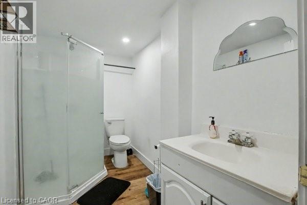 Full bathroom featuring a white vanity with integrated sink, chrome-finish faucet, and a wall-mounted mirror - 37 Wellington Street, Cambridge, ON