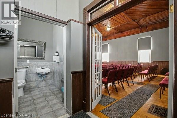 Main gathering area with wood-finish flooring and a distinctive wood-slat ceiling - 37 Wellington Street, Cambridge, ON