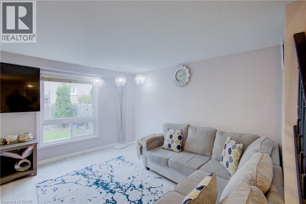 Bright living area featuring wood-finish flooring and a large window - 53 Prosperity Drive, Kitchener, ON - Indoor