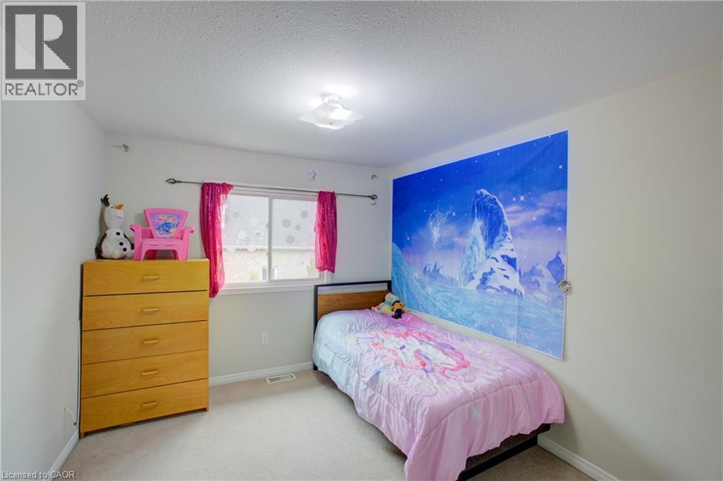 Carpeted room featuring a single window with white trim, a flush-mount ceiling light fixture, and light-colored walls - 53 Prosperity Drive, Kitchener, ON - Indoor Photo Showing Bedroom