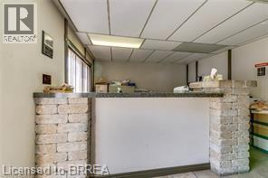 Reception counter featuring stone block accents and a dark-toned countertop - 9 Meadow Lane S, Hamilton, ON