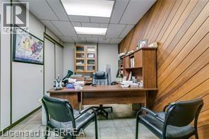 Office space with wood-paneled wall, recessed lighting, built-in shelving, and wood-finish flooring - 9 Meadow Lane S, Hamilton, ON