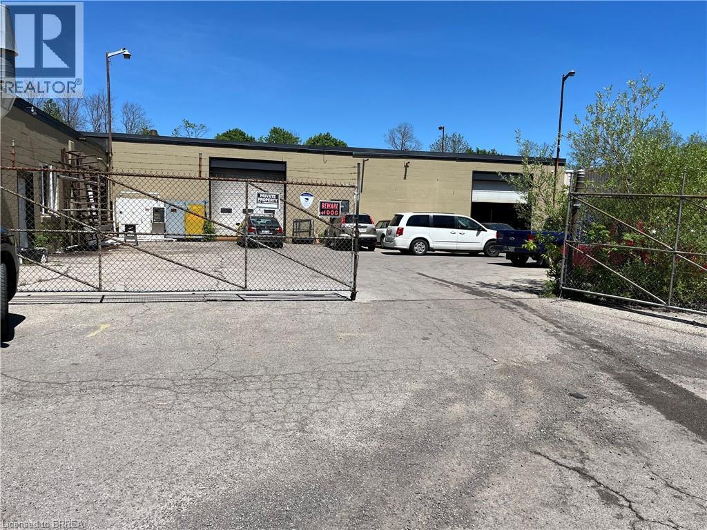 Paved lot with chain-link fencing and gate entry - 9 Meadow Lane S, Hamilton, ON