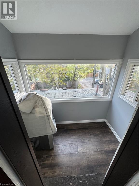 Wood-finish flooring, white baseboards, and neutral grey walls - 61 Waterloo Drive, Kitchener, ON - Indoor Photo Showing Other Room