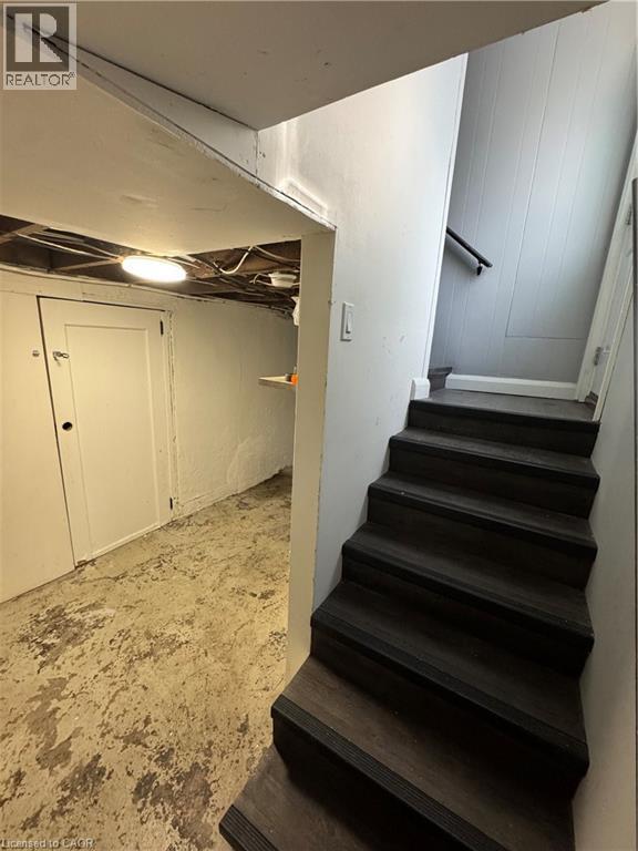 Staircase with dark wood-finish treads and risers, complemented by a black handrail - 61 Waterloo Drive, Kitchener, ON - Indoor Photo Showing Other Room