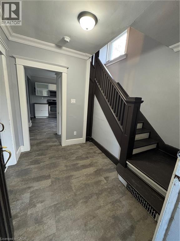Entryway featuring wood-finish flooring, a dark wood staircase with white risers, and white trim - 61 Waterloo Drive, Kitchener, ON - Indoor Photo Showing Other Room