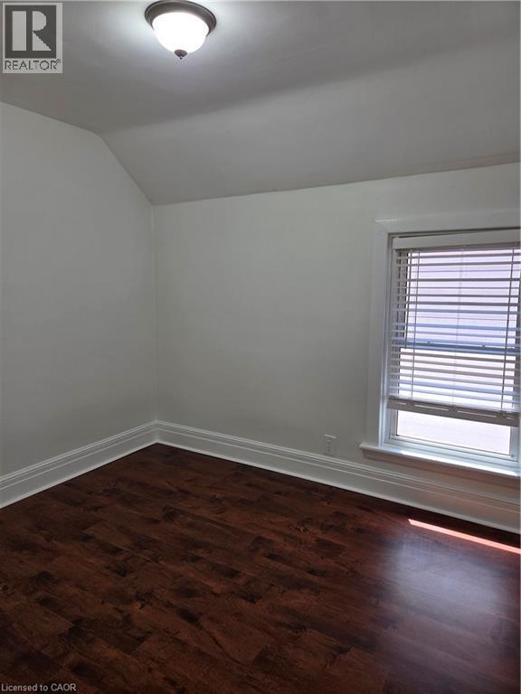 Room featuring rich wood-finish flooring, white baseboards, and a window with blinds - 125 Cavell Avenue, Hamilton, ON - Indoor Photo Showing Other Room