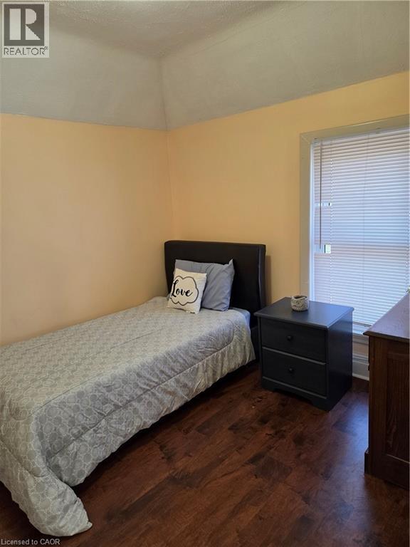 Room featuring wood-finish flooring, a window with blinds, and light-toned walls - 125 Cavell Avenue, Hamilton, ON - Indoor Photo Showing Bedroom