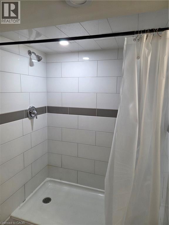 Walk-in shower with white subway tile surround, accenting gray tile band, chrome fixtures, and recessed lighting - 125 Cavell Avenue, Hamilton, ON - Indoor Photo Showing Bathroom