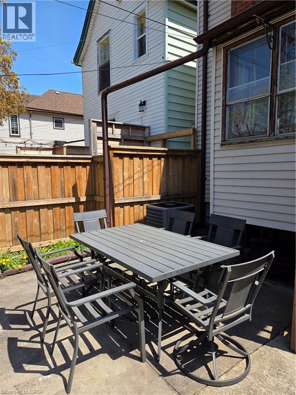 Paved patio area featuring a wooden privacy fence - 125 Cavell Avenue, Hamilton, ON - Outdoor With Deck Patio Veranda With Exterior