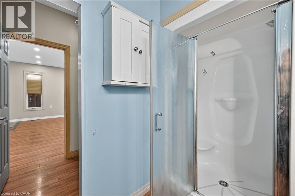 Walk-in shower with a glass enclosure, integrated seating, and a chrome showerhead - 704 Stone Church Road E, Hamilton, ON - Indoor Photo Showing Bathroom