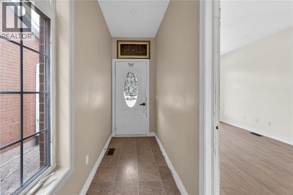 Entryway featuring durable tile flooring and a window with grid detailing - 704 Stone Church Road E, Hamilton, ON - Indoor Photo Showing Other Room