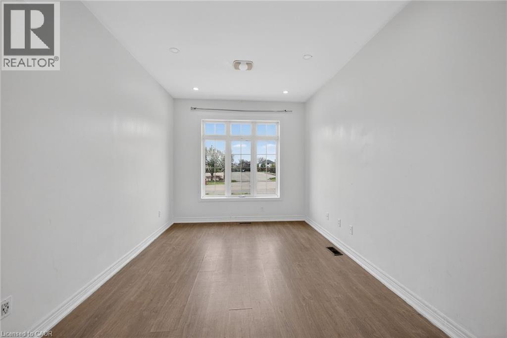 Bright interior space featuring a large multiple-pane window, recessed lighting, and wood-finish flooring - 704 Stone Church Road E, Hamilton, ON - Indoor Photo Showing Other Room