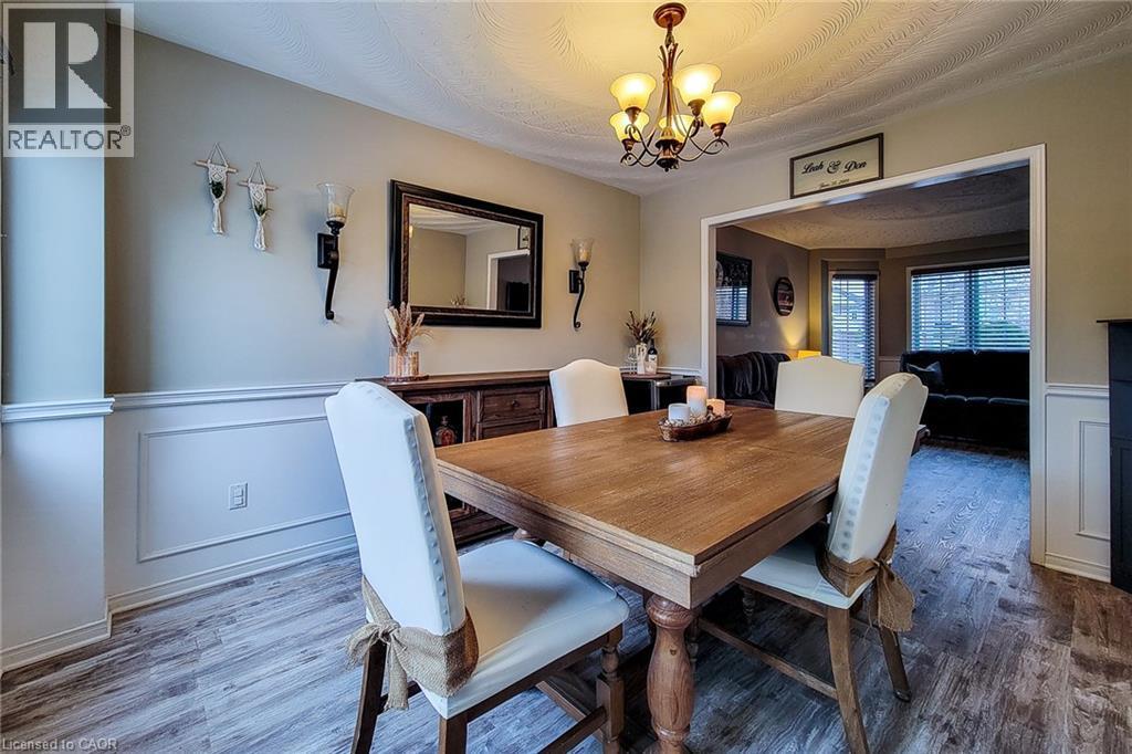 Dining area featuring wood-finish flooring, wainscoting, and a decorative chandelier - 146 Locheed Drive, Hamilton, ON - Indoor Photo Showing Dining Room