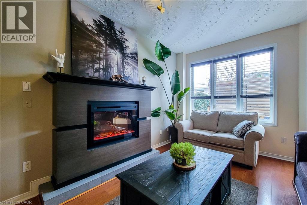 Built-in electric fireplace with a dark wood-finish surround and hearth - 146 Locheed Drive, Hamilton, ON - Indoor Photo Showing Living Room With Fireplace