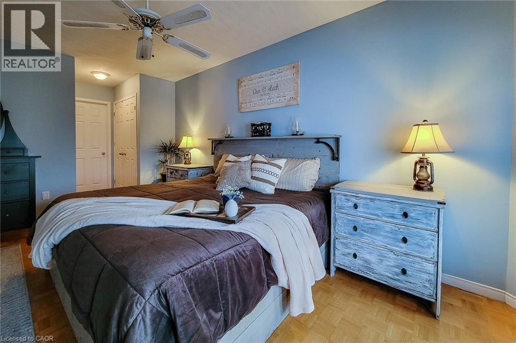 Bedroom featuring a ceiling fan with integrated lighting, two panel doors, and wood-finish flooring - 146 Locheed Drive, Hamilton, ON - Indoor Photo Showing Bedroom
