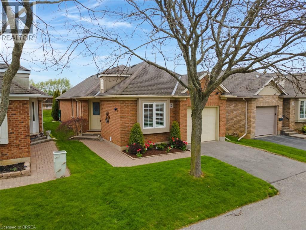Brick exterior residence featuring a covered front entrance, bay window, and attached garage - 422 Powerline Road Unit# 10, Brantford, ON - Outdoor