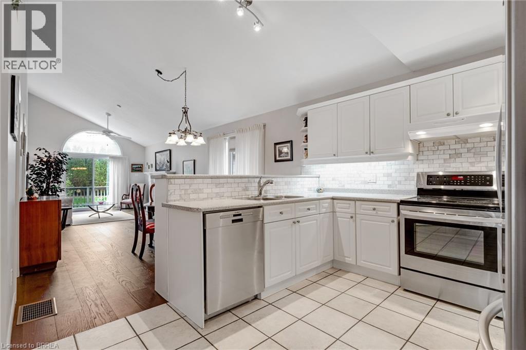 Kitchen featuring white cabinetry, stainless steel appliances, subway tile backsplash, and light-toned countertops - 422 Powerline Road Unit# 10, Brantford, ON - Indoor Photo Showing Kitchen