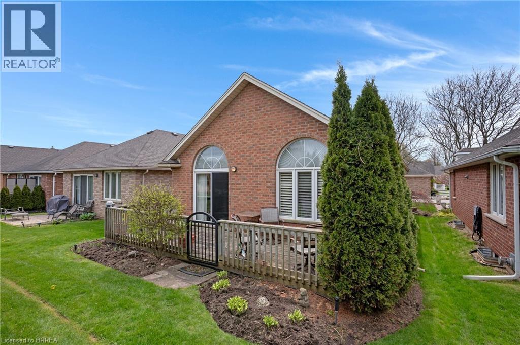 Brick exterior featuring a private patio area with a wooden fence and gate - 422 Powerline Road Unit# 10, Brantford, ON - Outdoor