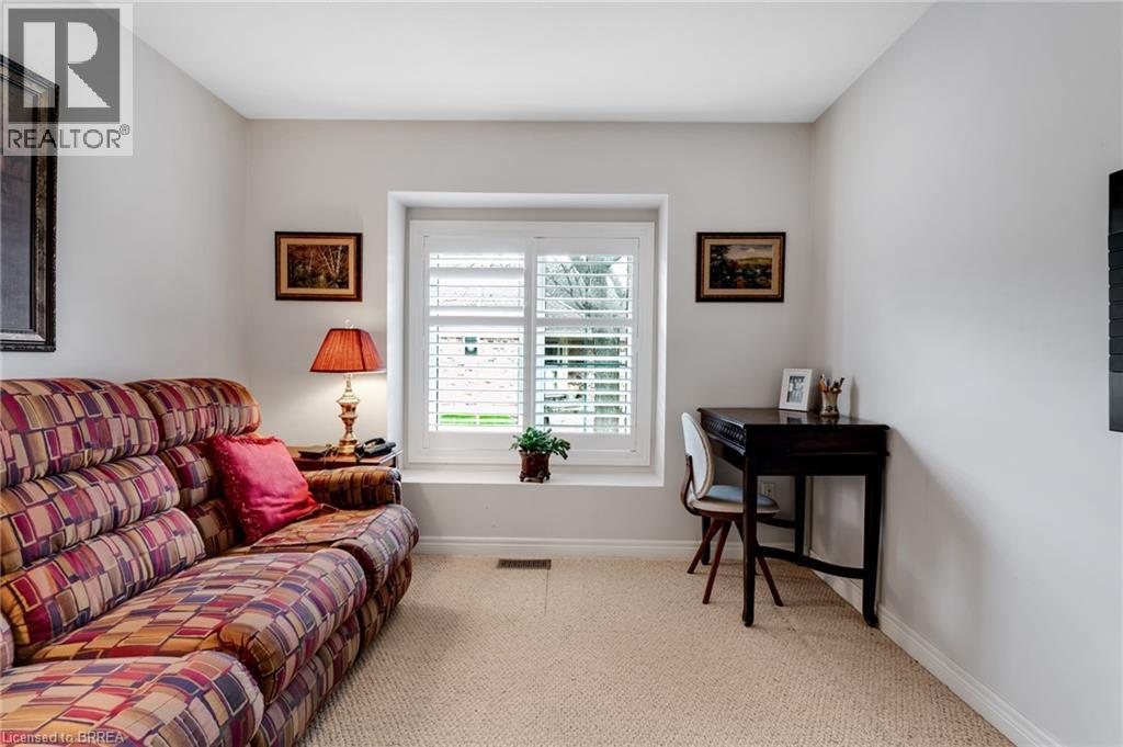 Carpeted room featuring a window with white plantation shutters and a built-in window seat - 422 Powerline Road Unit# 10, Brantford, ON - Indoor