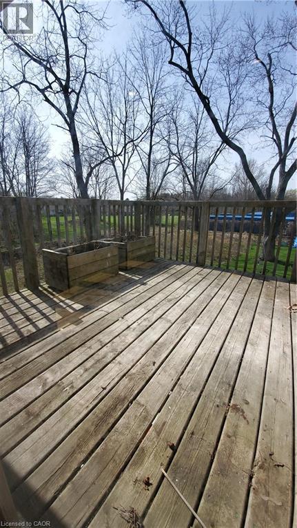 Wood deck with a slatted railing overlooking a treed landscape - 3355 King Street E, Kitchener, ON - Outdoor