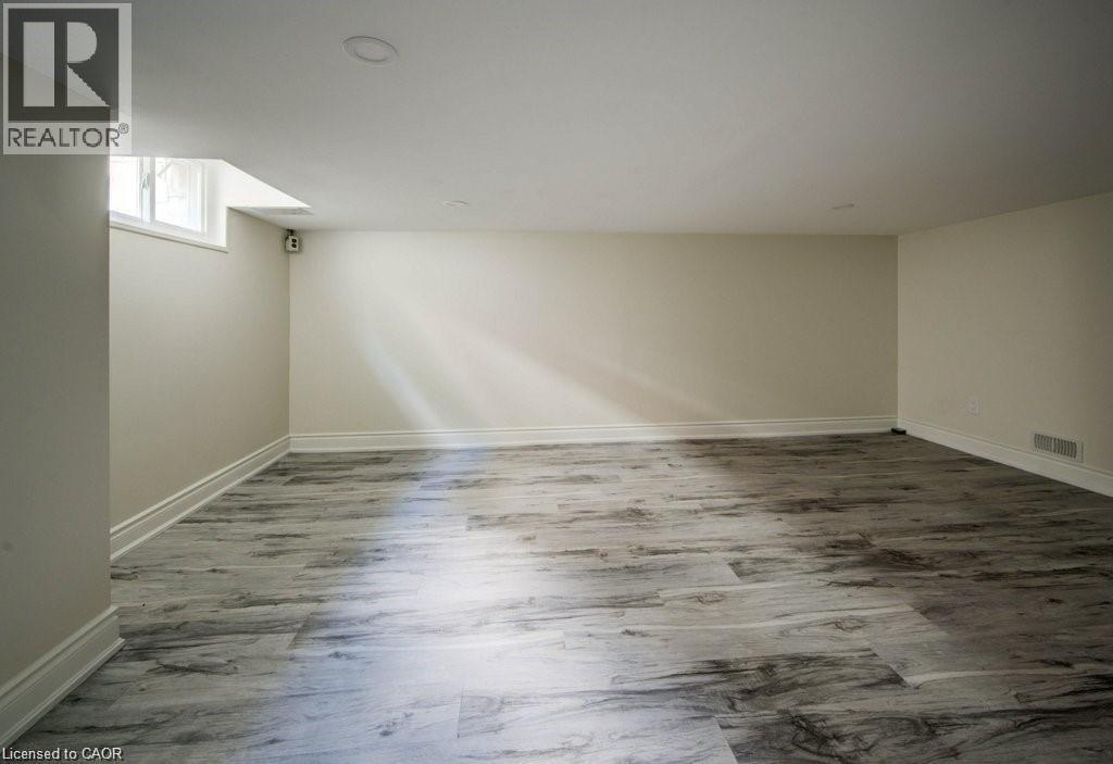 Spacious room featuring wood-finish flooring, light-toned walls, and recessed ceiling lighting - 33 Sixth Avenue, Kitchener, ON - Indoor Photo Showing Other Room