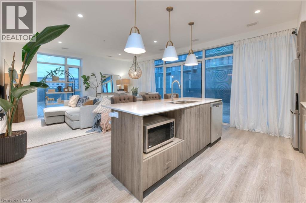 Kitchen featuring modern cabinets, an island with sink, stainless steel appliances, and light wood-type flooring - 50 Grand Avenue S Unit# 602, Cambridge, ON - Indoor
