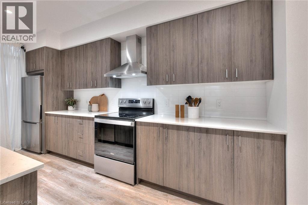 Kitchen with modern cabinets, stainless steel appliances, tasteful backsplash, light wood-style flooring, and light stone countertops - 50 Grand Avenue S Unit# 602, Cambridge, ON - Indoor Photo Showing Kitchen