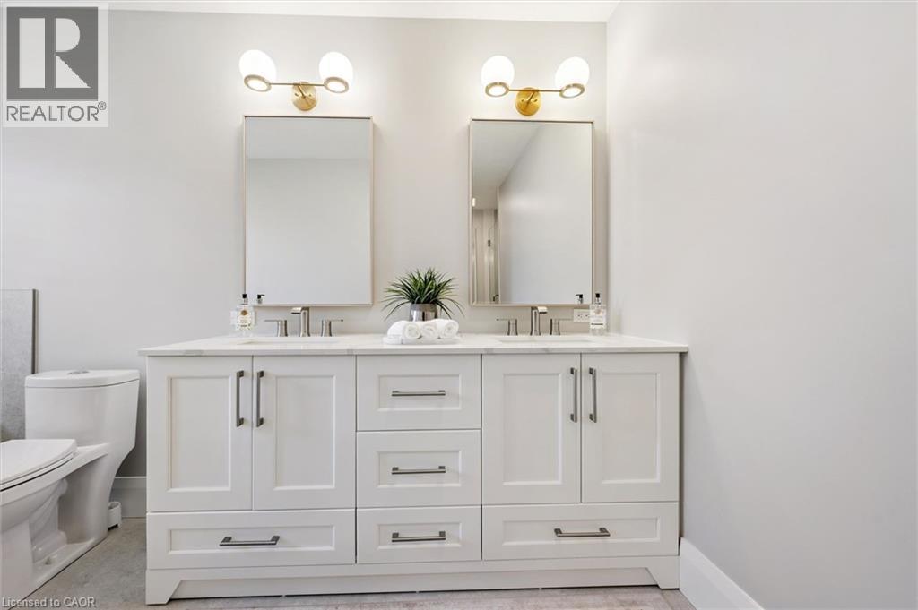 Dual vanity with white shaker cabinetry, brushed nickel hardware, and an integrated countertop - 72 Elmbank Trail, Kitchener, ON - Indoor Photo Showing Bathroom