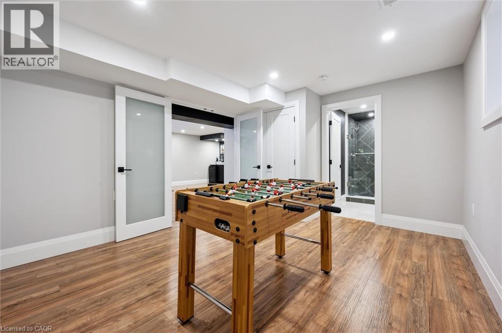 Spacious room featuring wood-finish flooring, recessed lighting, and a neutral wall palette - 72 Elmbank Trail, Kitchener, ON - Indoor Photo Showing Other Room