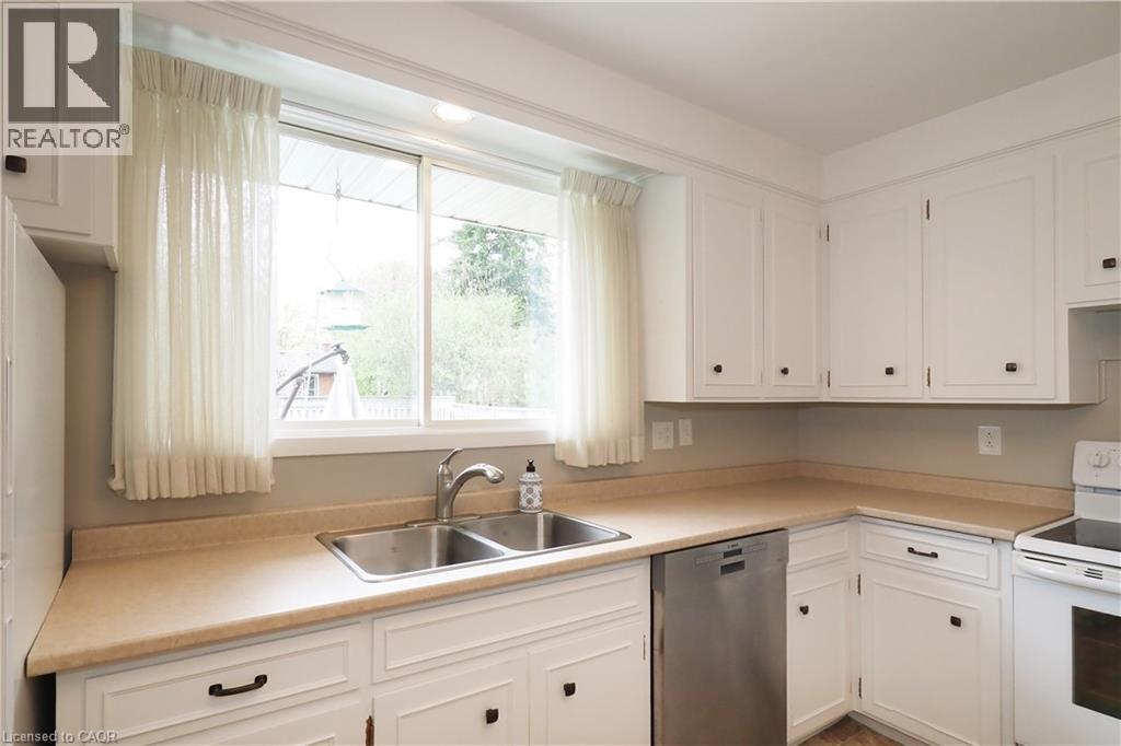 kitchen window framed by cabinetry with sink & countertop - 76 Cloverdale Crescent, Kitchener, ON - Indoor Photo Showing Kitchen With Double Sink