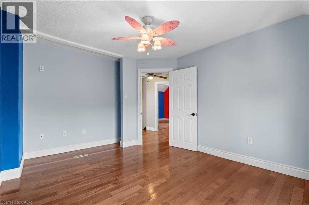 Interior room featuring wood-finish flooring, light blue walls, and a ceiling fan with integrated lighting - 204 Beach Boulevard, Hamilton, ON - Indoor Photo Showing Other Room