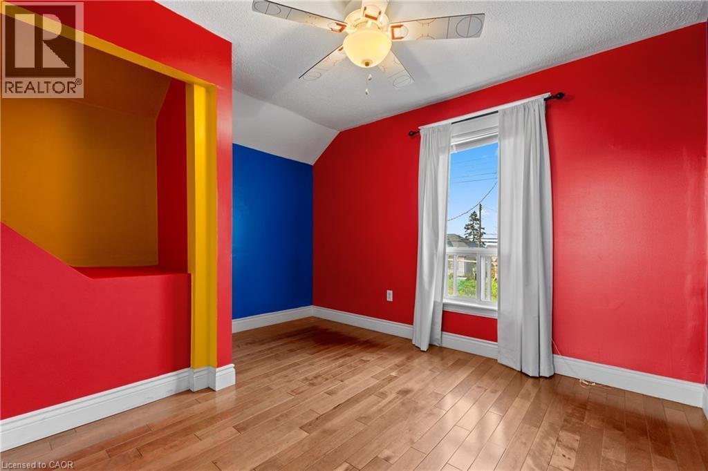 Wood-finish flooring throughout, featuring painted walls and a prominent window - 204 Beach Boulevard, Hamilton, ON - Indoor Photo Showing Other Room