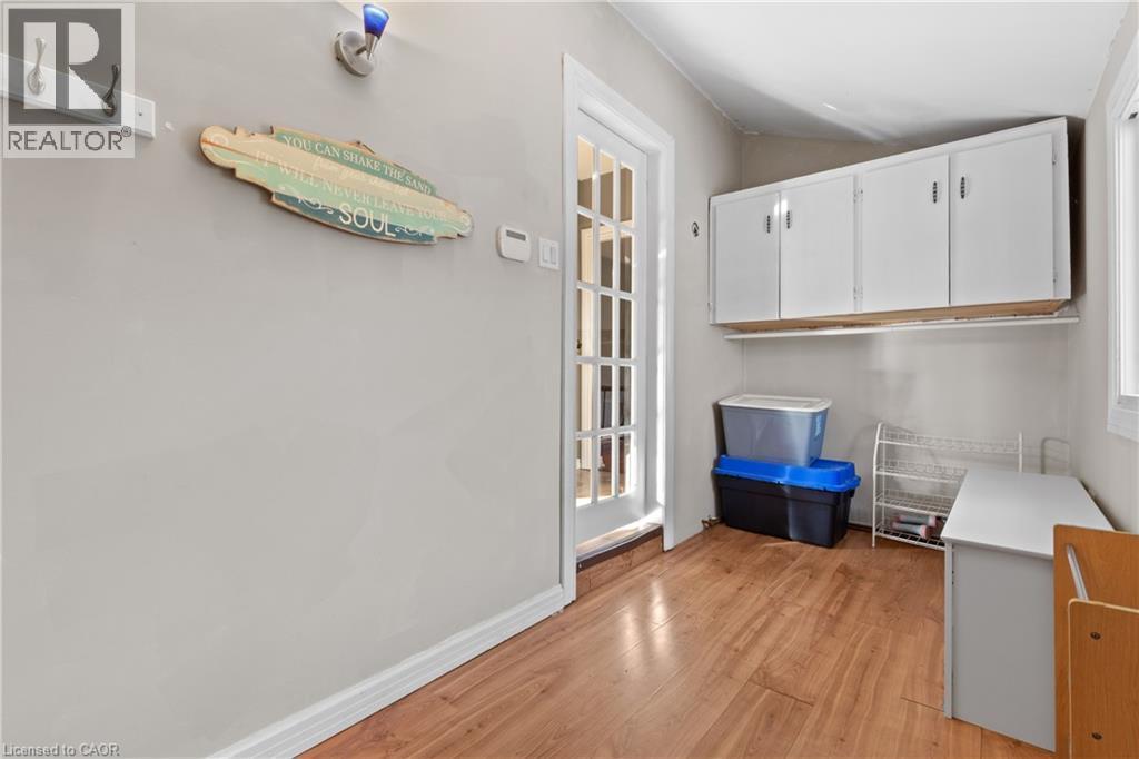 Mudroom entryway featuring wood-finish flooring, a white paneled door, and a large window with white trim - 204 Beach Boulevard, Hamilton, ON - Indoor Photo Showing Other Room