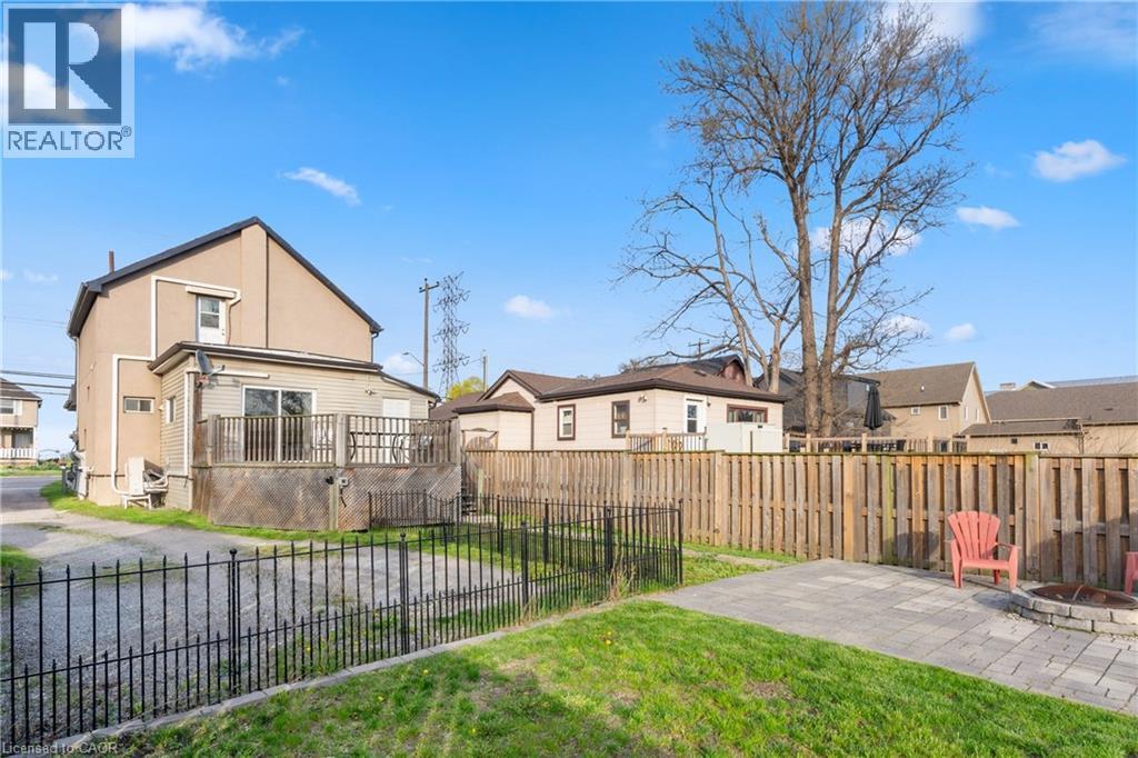 Expansive rear yard featuring a paved patio area, fire pit, and wooden privacy fencing - 204 Beach Boulevard, Hamilton, ON - Outdoor