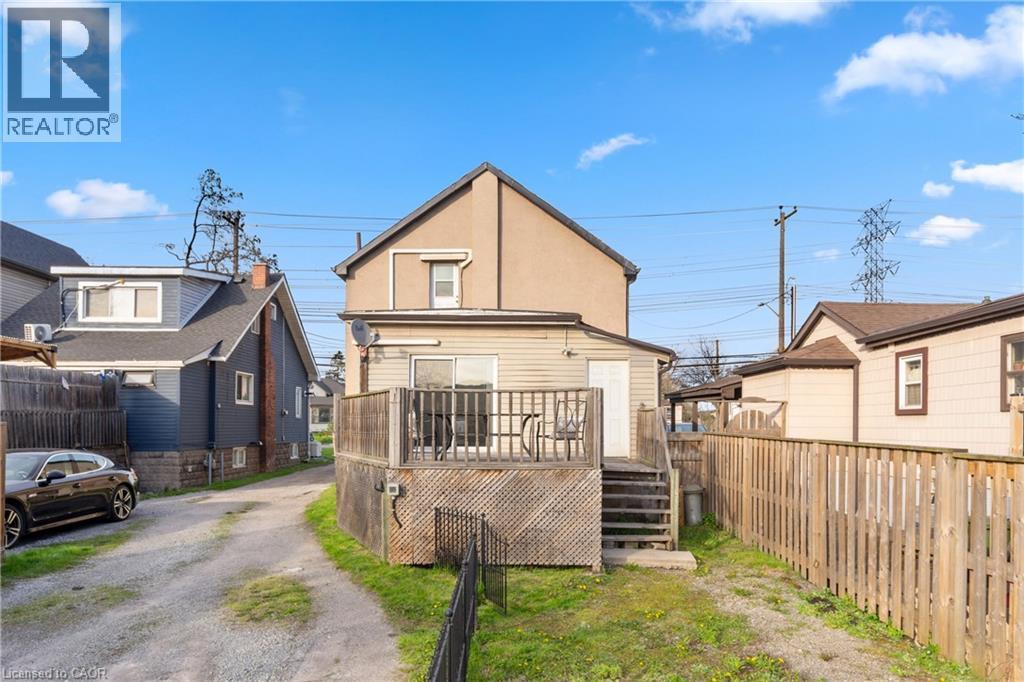 Rear exterior featuring a wood deck with railing, sliding glass door access, and a wooden privacy fence - 204 Beach Boulevard, Hamilton, ON - Outdoor