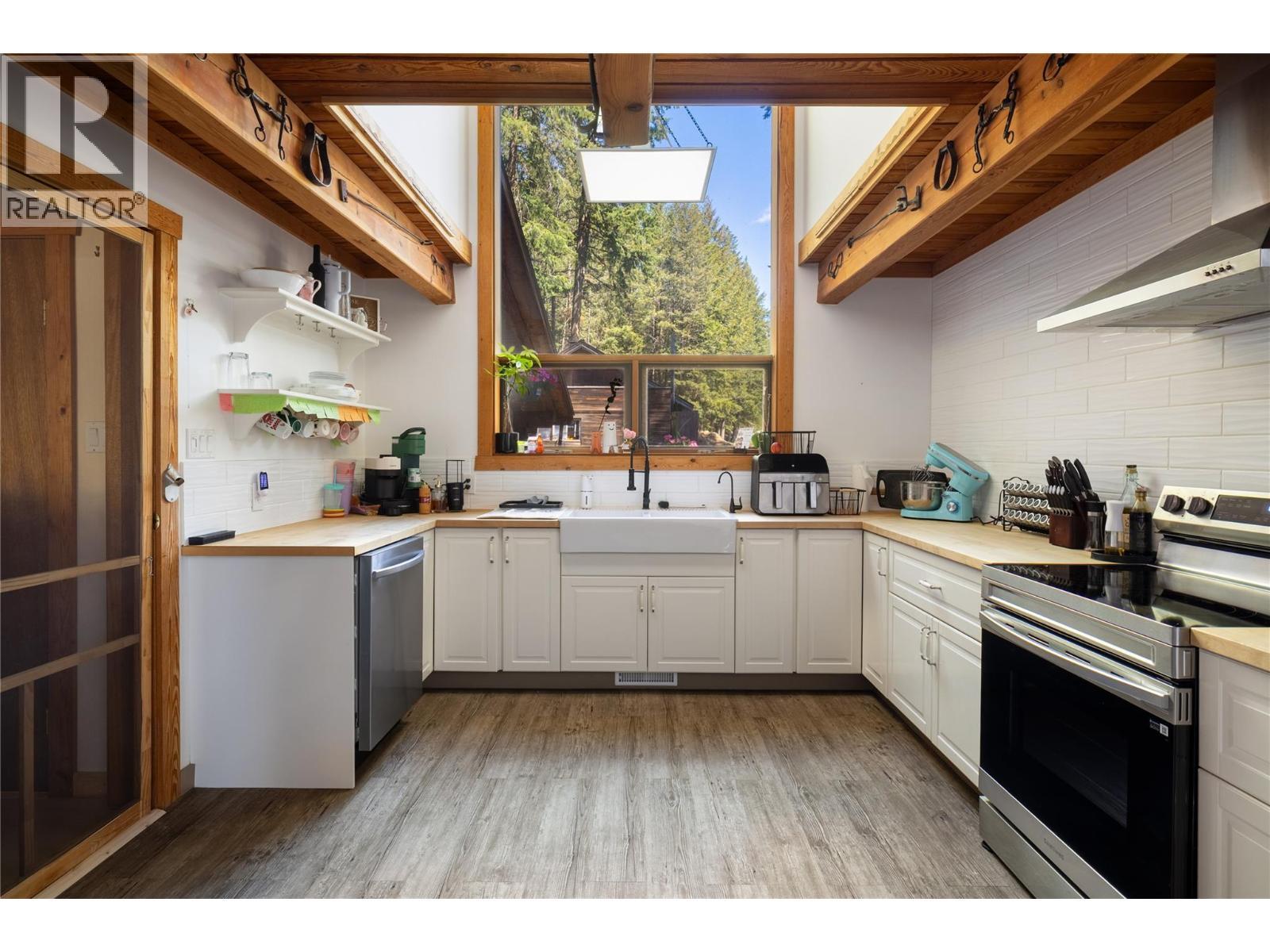 Kitchen with wood beams, vaulted ceiling and a large window - 4644 97 Highway, Westwold, BC - Indoor Photo Showing Kitchen